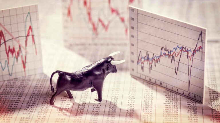 Bull toy looking at market charts