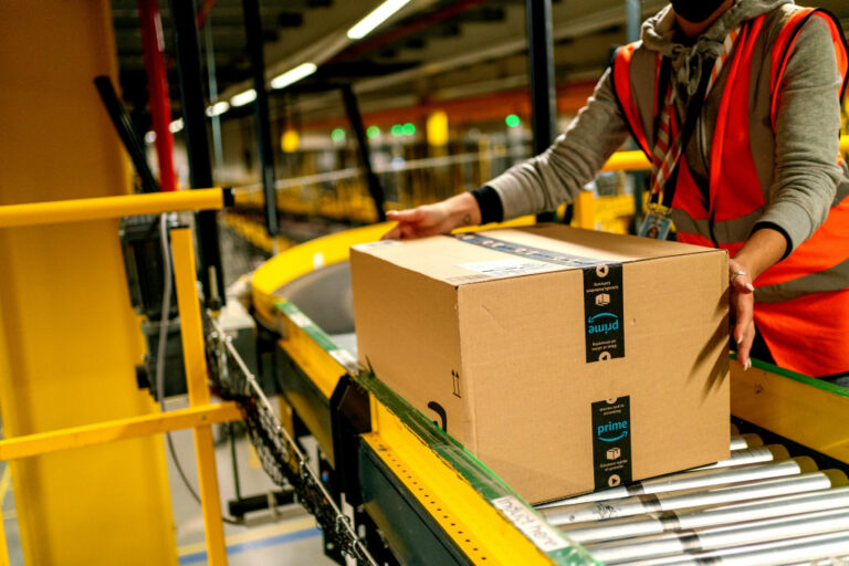 A worker collects an Amazon Prime customer order package from a conveyor at an Amazon.com Inc. fulfillment center in Frankenthal, Germany, on Tuesday, Oct. 13, 2020.