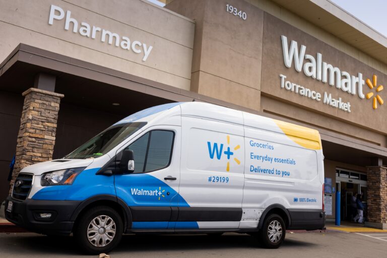 A Walmart Plus van outside a Walmart store.